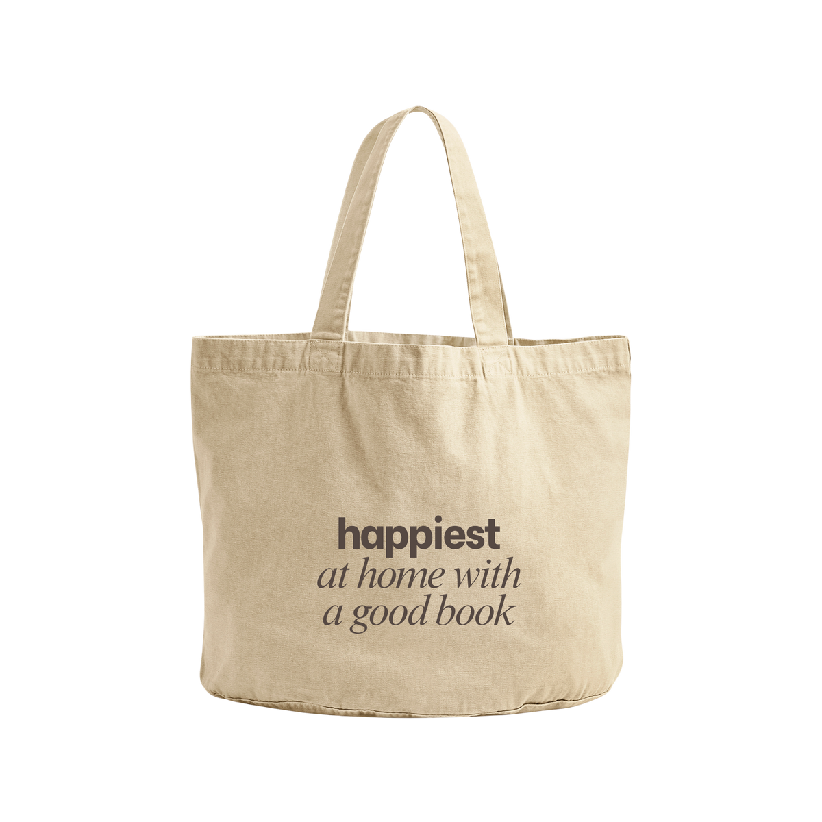 A natural canvas tote bag with the text 'happiest at home with a good book' printed in dark brown on the front, set against a plain white background.