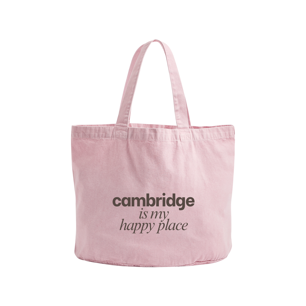 A light pink canvas tote bag with two shoulder straps, featuring the printed text 'cambridge is my happy place' in black on the front, set against a plain white background.