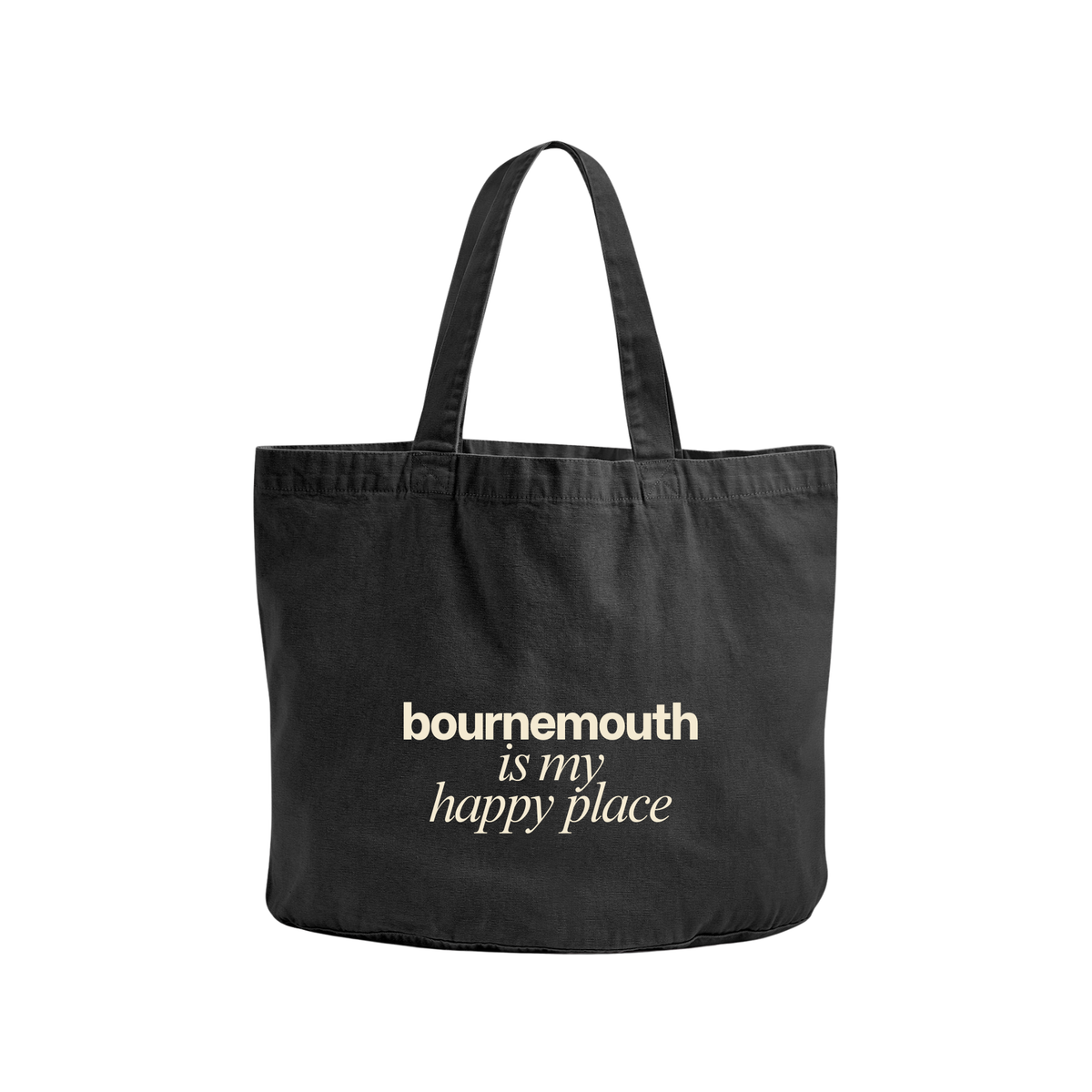 A black canvas tote bag with two shoulder straps, featuring the text 'bournemouth is my happy place' printed in a light cream-colored serif font on the front, set against a plain white background.